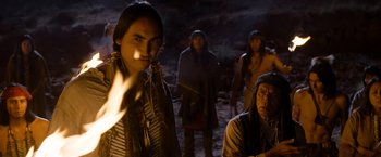 Movie still from “A Million Ways to Die in the West” (2014), directed by Seth MacFarlane – A group of native americans standing around a fire; Medium shot, Over the shoulder angle