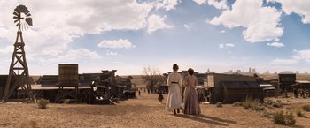 Movie still from “A Million Ways to Die in the West” (2014), directed by Seth MacFarlane – A couple of people walking down a dirt road; Extreme Wide shot, Low angle