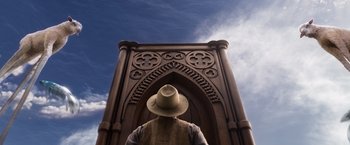 Movie still from “A Million Ways to Die in the West” (2014), directed by Seth MacFarlane – A man wearing a hat standing in front of a building; Wide shot, Low angle