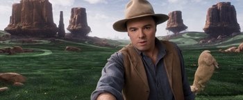 Movie still from “A Million Ways to Die in the West” (2014), directed by Seth MacFarlane – A man wearing a hat standing in front of a field; Close Up shot, Over the shoulder angle