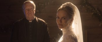 Movie still from “A Million Ways to Die in the West” (2014), directed by Seth MacFarlane – A man and a woman standing next to each other in front of a wooden wall; Close Up shot, Over the shoulder angle