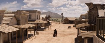Movie still from “A Million Ways to Die in the West” (2014), directed by Seth MacFarlane – An old western town with a man in a black suit; Extreme Wide shot, High angle