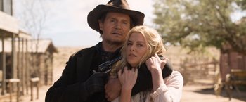 Movie still from “A Million Ways to Die in the West” (2014), directed by Seth MacFarlane – A man and a woman holding a gun and posing for a picture; Close Up shot, Over the shoulder angle