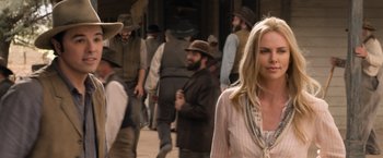 Movie still from “A Million Ways to Die in the West” (2014), directed by Seth MacFarlane – A group of people walking down a street; Medium shot, Over the shoulder angle