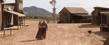 Movie still from “A Million Ways to Die in the West” (2014), directed by Seth MacFarlane – A man and a woman walking in front of a windmill; Wide shot, Over the shoulder angle
