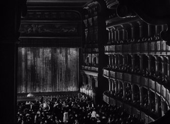 Movie still from “A Night at the Opera” (1935), directed by Sam Wood – An audience is gathered in an old theater; Extreme Wide shot, High angle