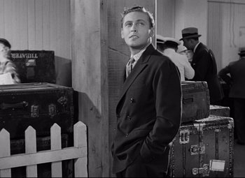 Movie still from “A Night at the Opera” (1935), directed by Sam Wood – A man in a suit standing next to a bunch of suitcases; Medium shot, Over the shoulder angle