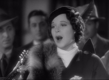 Movie still from “A Night at the Opera” (1935), directed by Sam Wood – An old photo of a woman singing in front of a crowd; Close Up shot, Low angle