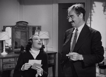 Movie still from “A Night at the Opera” (1935), directed by Sam Wood – An old photo of a man and a young woman talking to each other; Medium shot, Low angle