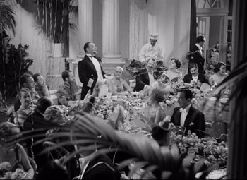 Movie still from “A Night at the Opera” (1935), directed by Sam Wood – A group of people sitting at a table with food; Wide shot, High angle