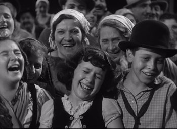 Movie still from “A Night at the Opera” (1935), directed by Sam Wood – A group of people that are laughing together; Medium shot, High angle