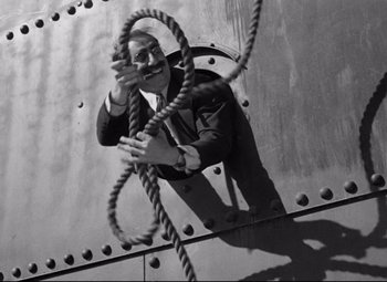 Movie still from “A Night at the Opera” (1935), directed by Sam Wood – A black and white photo of a man holding a rope; Medium shot, Low angle