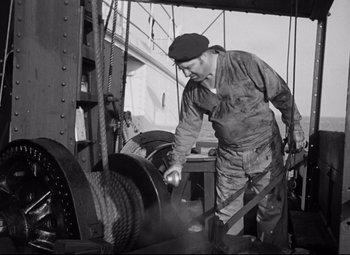 Movie still from “A Night at the Opera” (1935), directed by Sam Wood – An old black and white photo of a man working on a machine; Medium shot, Low angle