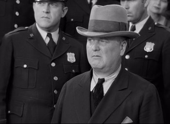 Movie still from “A Night at the Opera” (1935), directed by Sam Wood – An old photo of a man in a suit and a hat; Close Up shot, Low angle