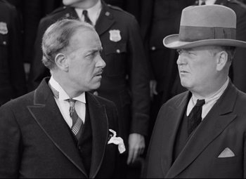 Movie still from “A Night at the Opera” (1935), directed by Sam Wood – A black and white photo of two men in suits; Medium shot, Over the shoulder angle
