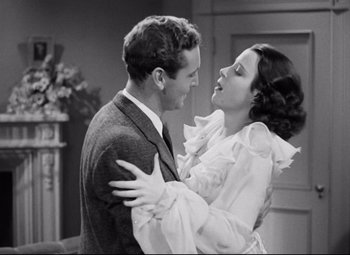 Movie still from “A Night at the Opera” (1935), directed by Sam Wood – A man and a woman embracing each other in front of a fireplace; Medium shot, High angle