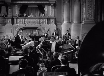 Movie still from “A Night at the Opera” (1935), directed by Sam Wood – A black and white photo of a orchestra performing; Extreme Wide shot, High angle