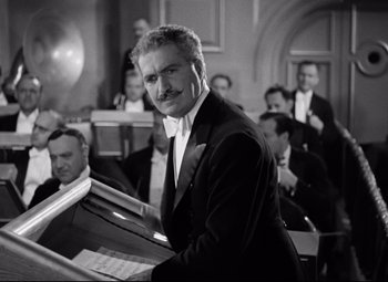 Movie still from “A Night at the Opera” (1935), directed by Sam Wood – A black and white photo of a man in a suit and bow tie; Medium shot, Low angle