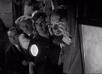 Movie still from “A Night at the Opera” (1935), directed by Sam Wood – A black and white photo of a group of men looking out of a window; Medium shot, Low angle