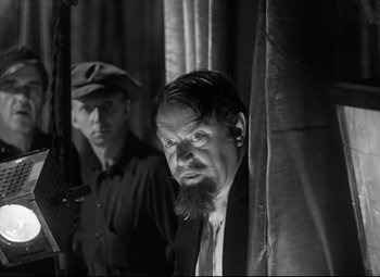 Movie still from “A Night at the Opera” (1935), directed by Sam Wood – A man with a long beard standing next to another man; Medium shot, Over the shoulder angle