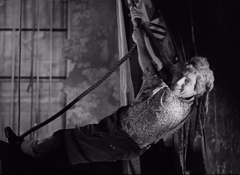 Movie still from “A Night at the Opera” (1935), directed by Sam Wood – An older woman hanging from a rope on a wall; Medium shot, Low angle