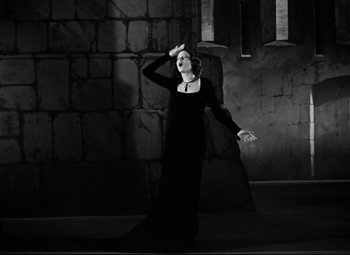 Movie still from “A Night at the Opera” (1935), directed by Sam Wood – A woman dressed as morticia in a black dress; Medium shot, Low angle