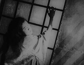 An old black and white photo of a woman laying on the ground