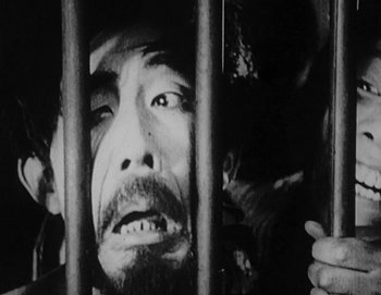 A black and white photo of a man behind bars