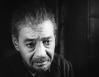 An older man is looking at the camera