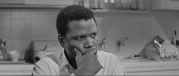 A black and white photo of a man with his hand on his face