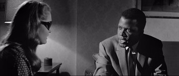 A black and white photo of a man sitting in a chair