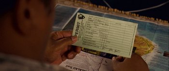 Movie still from “A Perfect Getaway” (2009), directed by David Twohy – A person holding a permit in their hand; Extreme Close Up shot, High angle