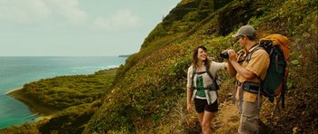 Movie still from “A Perfect Getaway” (2009), directed by David Twohy – A woman is taking a picture while hiking on a trail; Wide shot, Over the shoulder angle