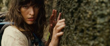 Movie still from “A Perfect Getaway” (2009), directed by David Twohy – A woman holding her hand up to the side of a tree; Close Up shot, Overhead angle