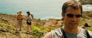 Movie still from “A Perfect Getaway” (2009), directed by David Twohy – A man and a woman walking on a cliff by the ocean; Close Up shot, Over the shoulder angle