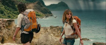 Movie still from “A Perfect Getaway” (2009), directed by David Twohy – A woman walking on a beach near a body of water; Wide shot, Low angle