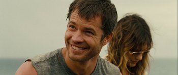 Movie still from “A Perfect Getaway” (2009), directed by David Twohy – A person with a smile on their face; Close Up shot, Over the shoulder angle