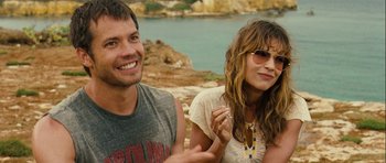 Movie still from “A Perfect Getaway” (2009), directed by David Twohy – A man and a woman sitting next to each other on the beach; Close Up shot, Over the shoulder angle
