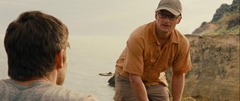 Movie still from “A Perfect Getaway” (2009), directed by David Twohy – A man standing next to a body of water; Close Up shot, Over the shoulder angle