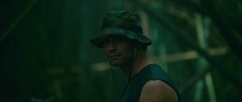 Movie still from “A Perfect Getaway” (2009), directed by David Twohy – A man wearing a camouflage hat in the woods; Close Up shot, Low angle