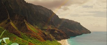 Movie still from “A Perfect Getaway” (2009), directed by David Twohy – A view of a beach and mountains with a rainbow in the background; Extreme Wide shot, High angle