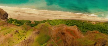Movie still from “A Perfect Getaway” (2009), directed by David Twohy – An aerial view of the ocean and a sandy beach; Extreme Wide shot, Overhead angle