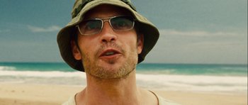 Movie still from “A Perfect Getaway” (2009), directed by David Twohy – A person wearing sunglasses and a hat; Close Up shot, Low angle