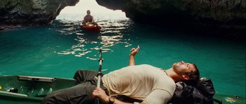 Movie still from “A Perfect Getaway” (2009), directed by David Twohy – Two people are fishing in the water near a boat; Wide shot, High angle