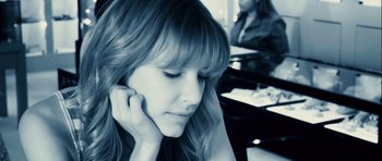 Movie still from “A Perfect Getaway” (2009), directed by David Twohy – A woman is sitting down and talking on a phone; Close Up shot, High angle