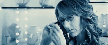 Movie still from “A Perfect Getaway” (2009), directed by David Twohy – A woman wearing glasses is talking on a phone; Close Up shot, High angle