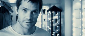 Movie still from “A Perfect Getaway” (2009), directed by David Twohy – A person wearing a white t - shirt; Close Up shot, Over the shoulder angle