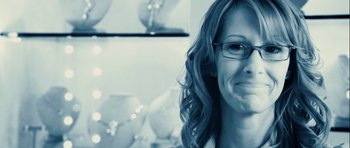 Movie still from “A Perfect Getaway” (2009), directed by David Twohy – A person wearing glasses and smiling; Close Up shot, Over the shoulder angle