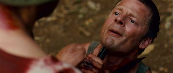 Movie still from “A Perfect Getaway” (2009), directed by David Twohy – A person with a knife in his mouth; Close Up shot, High angle