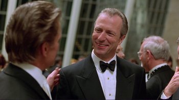 Movie still from “A Perfect Murder” (1998), directed by Andrew Davis – A man in a tuxedo smiling at another man; Close Up shot, Low angle